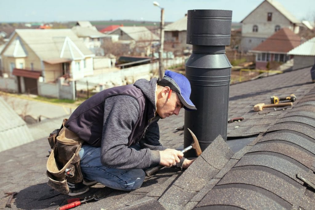 a-professional-master-roofer-with-hammer-repairs-the-roof
