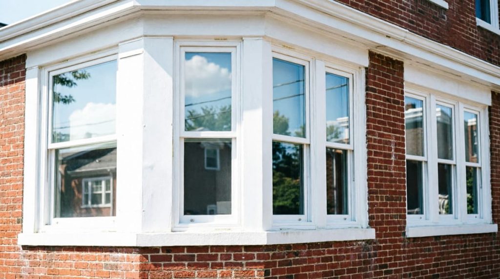 Newly installed energy-efficient white vinyl windows on Philadelphia rowhome, professional finish with clean trim work