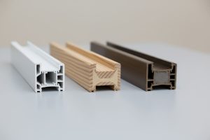 Corner cross-section samples of vinyl, wood, and fiberglass window frames compared side by side
