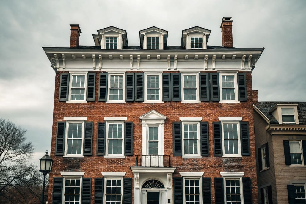 Painted wood double-hung windows with divided lites on a brick colonial home in a historic district